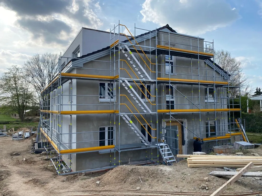Neubau-Villa im Rohbau, rundum eingerüstet mit Treppenaufgang